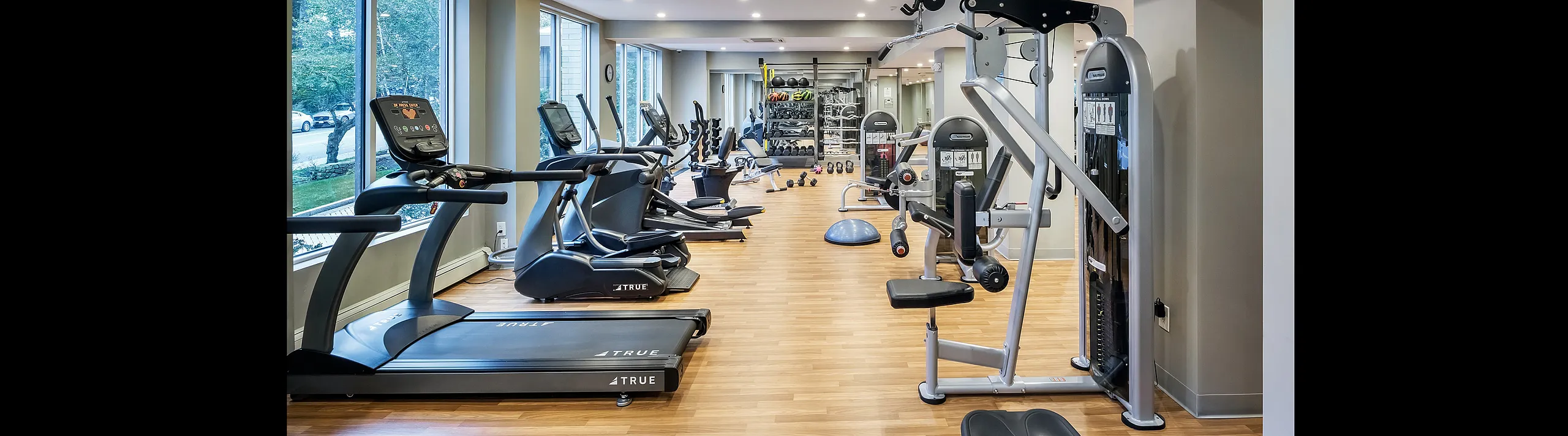 Bright and modern fitness center equipped with state-of-the-art cardio and strength training machines, offering a spacious and inviting workout environment.