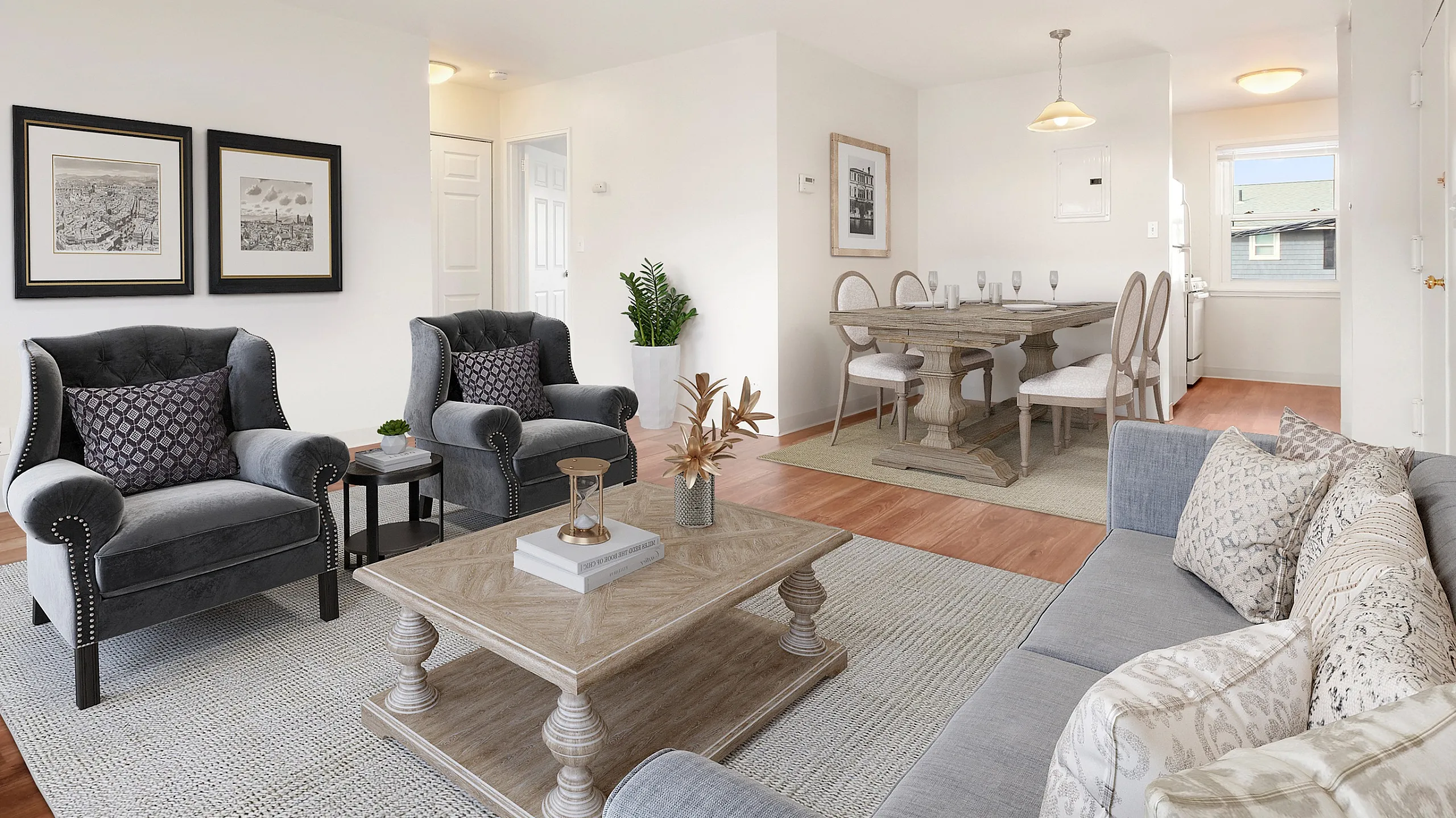Inviting living space with elegant gray armchairs, plush sofa, and chic dining area, perfect for entertaining in a beautifully lit setting.