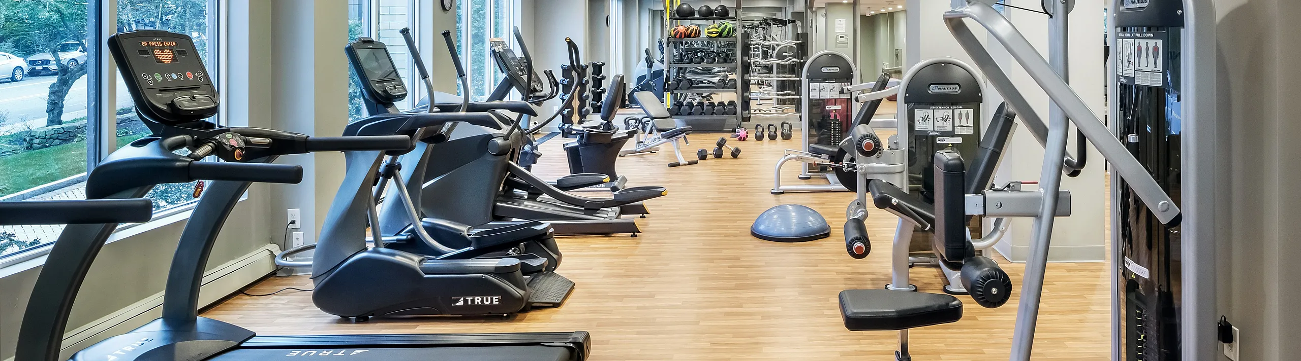 Bright and modern fitness center equipped with state-of-the-art cardio and strength training machines, offering a spacious and inviting workout environment.