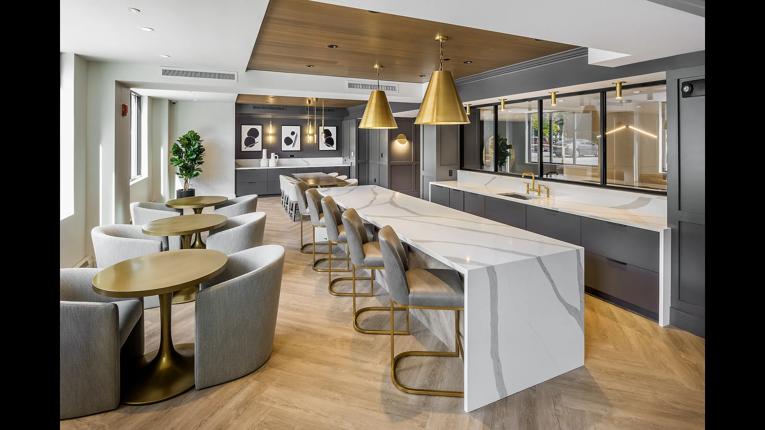 Modern communal dining area with sleek marble tables, plush seating, and stylish golden pendant lighting creating a luxurious ambiance.