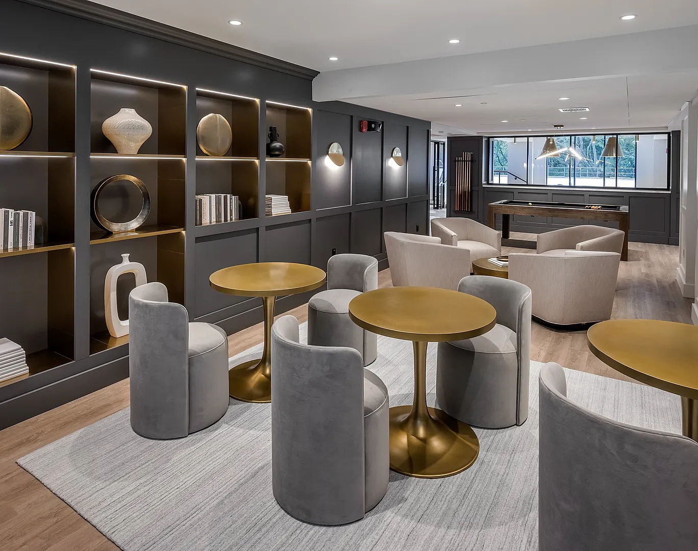 Sophisticated lounge space featuring modern decor, elegant gold tables, and plush seating with ample lighting.