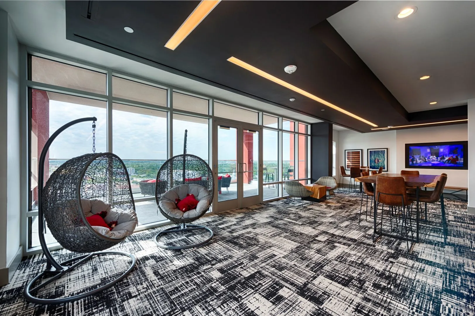 Chic modern lounge with hanging egg chairs, panoramic windows, and trendy decor, perfect for relaxation and social gatherings.