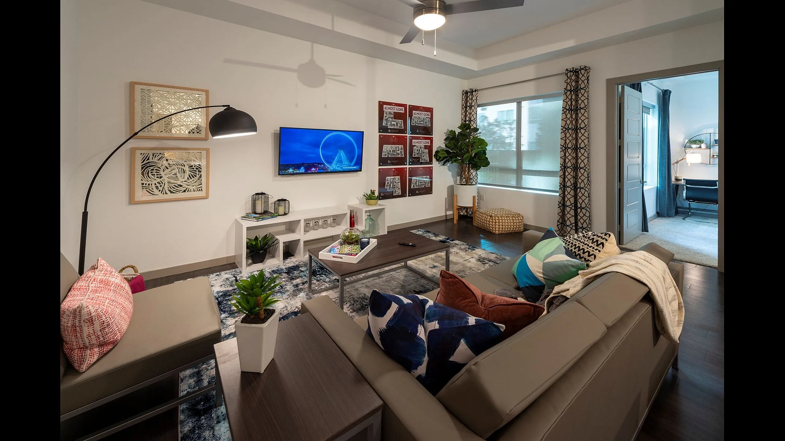 Chic living room with modern sectional sofa, vibrant decor, and large windows offering natural light and greenery. Perfect blend of style and comfort for contemporary living.