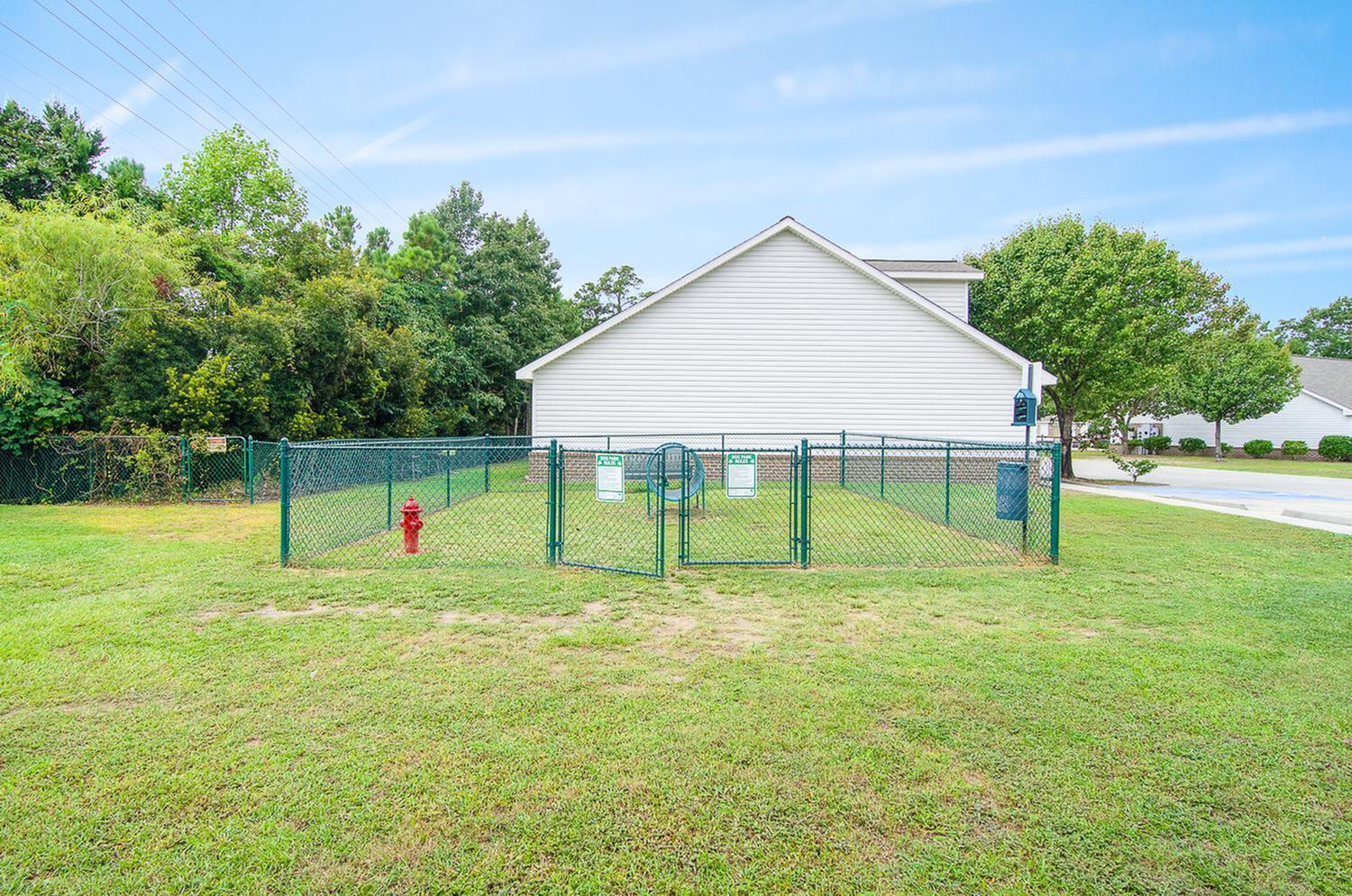Charming fenced pet area nestled in a lush green landscape, perfect for outdoor enjoyment and convenience.