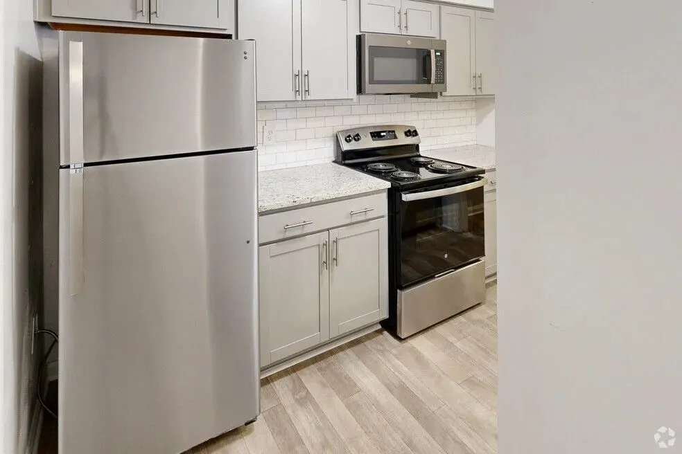 Modern kitchen with sleek stainless steel appliances, elegant white cabinetry, and stylish subway tile backsplash.