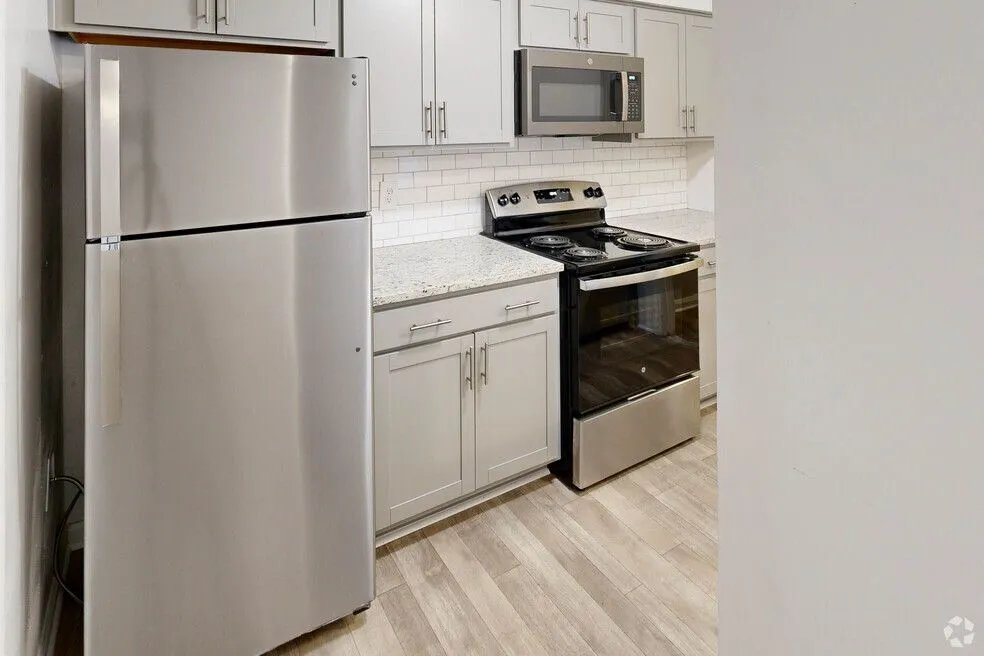 Modern kitchen with stainless steel appliances, sleek cabinetry, and elegant subway tile backsplash.