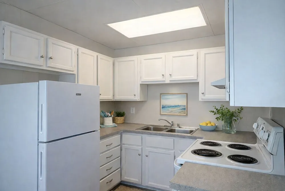 Bright, charming kitchen with white cabinetry, modern appliances, and tasteful decor, perfect for a cozy apartment setting.