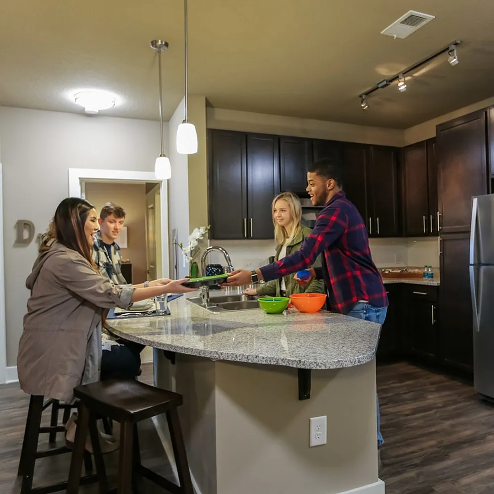 Modern kitchen with granite countertops and dark wood cabinets where friends enjoy a cozy gathering.