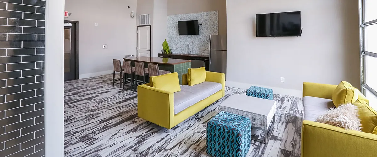Chic apartment interior with vibrant yellow sofas, modern dining area, and stylish decor under high ceilings.