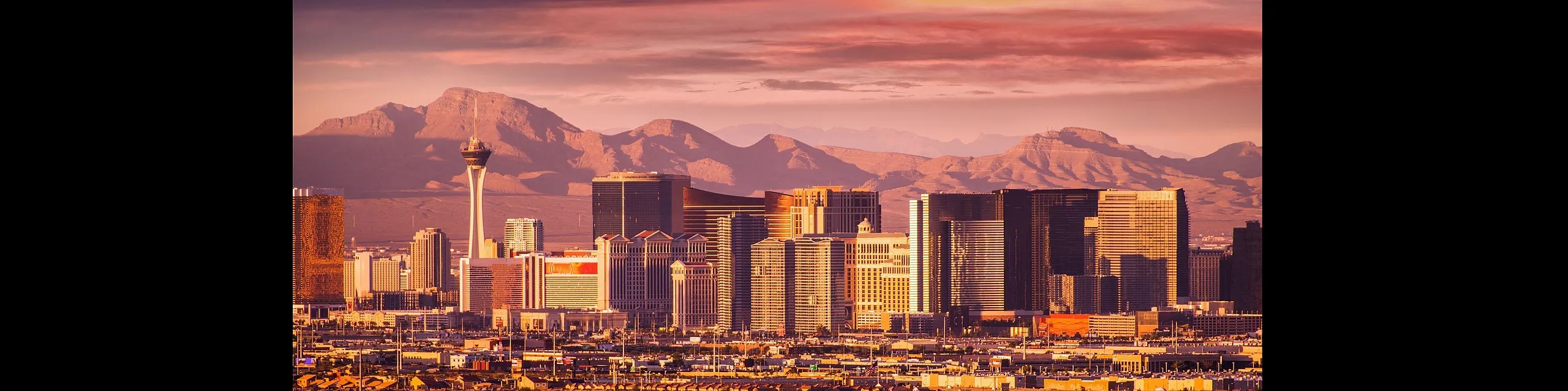 Breathtaking cityscape of a vibrant skyline against a mountainous backdrop at sunset, showcasing architectural marvels and urban allure.