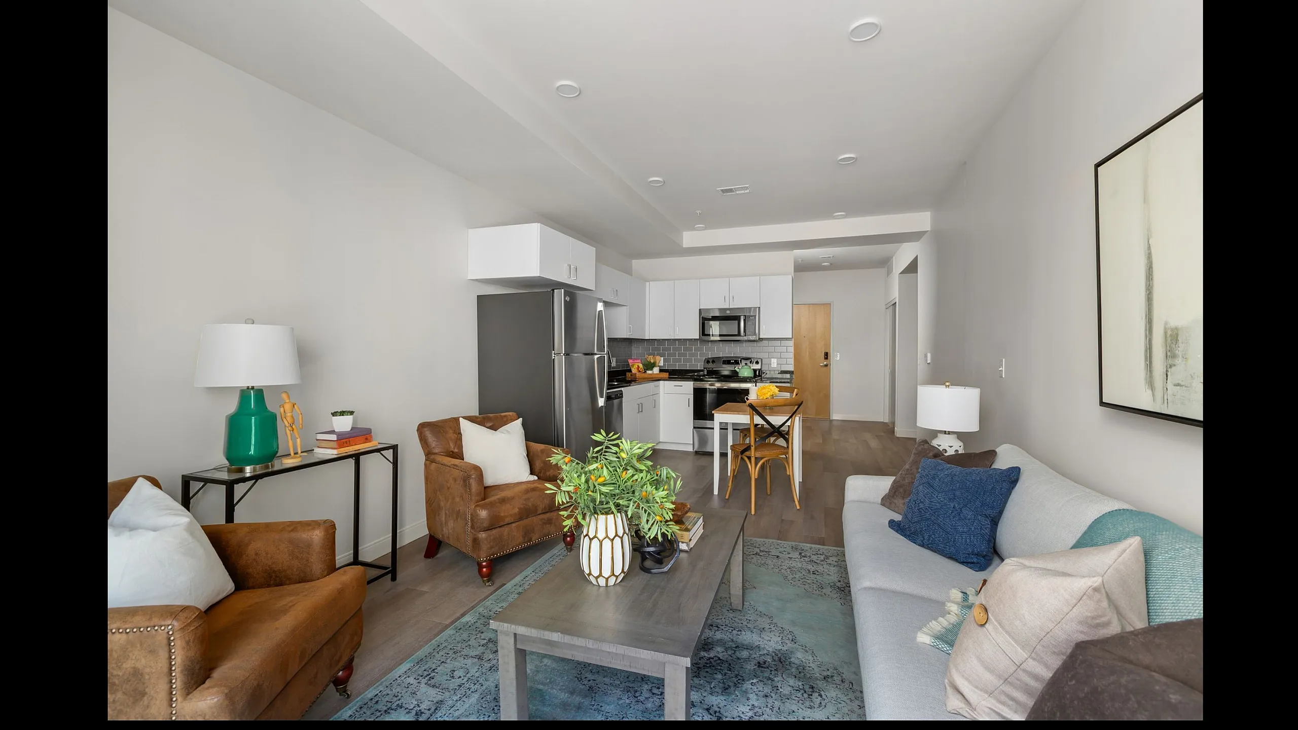 Chic apartment living room with modern kitchen, cozy seating, and stylish decor, perfect for entertaining.