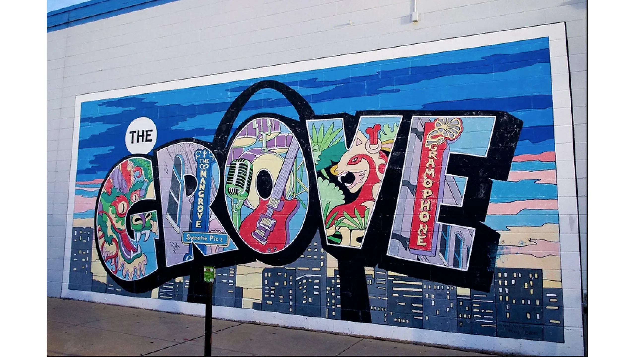Vibrant street mural showcasing the word 'THE GROOVE' filled with colorful illustrations of musical instruments, a jungle cat, and cityscape elements.