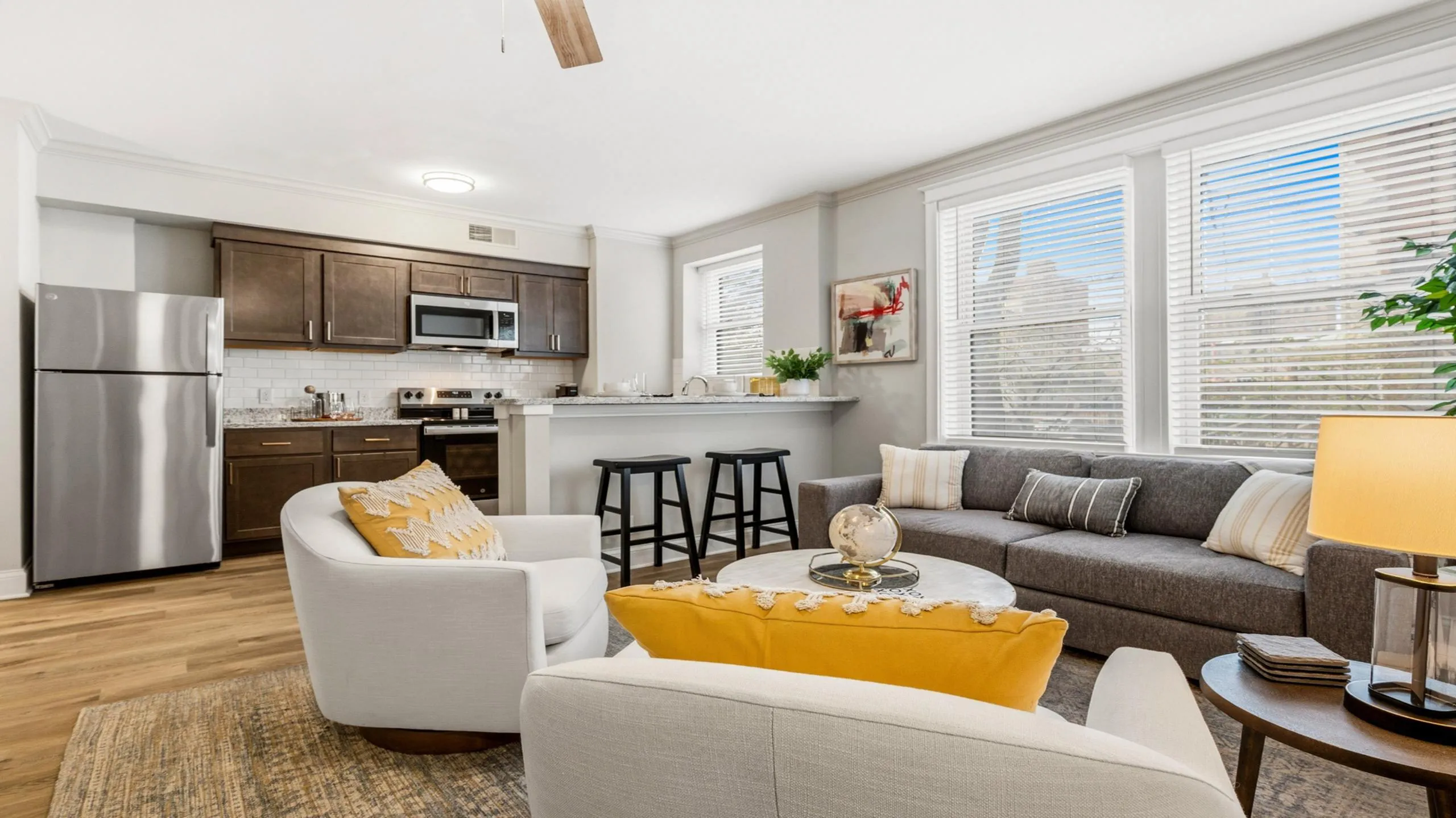 Inviting open-concept living space with modern kitchen, cozy seating, and abundant natural light.