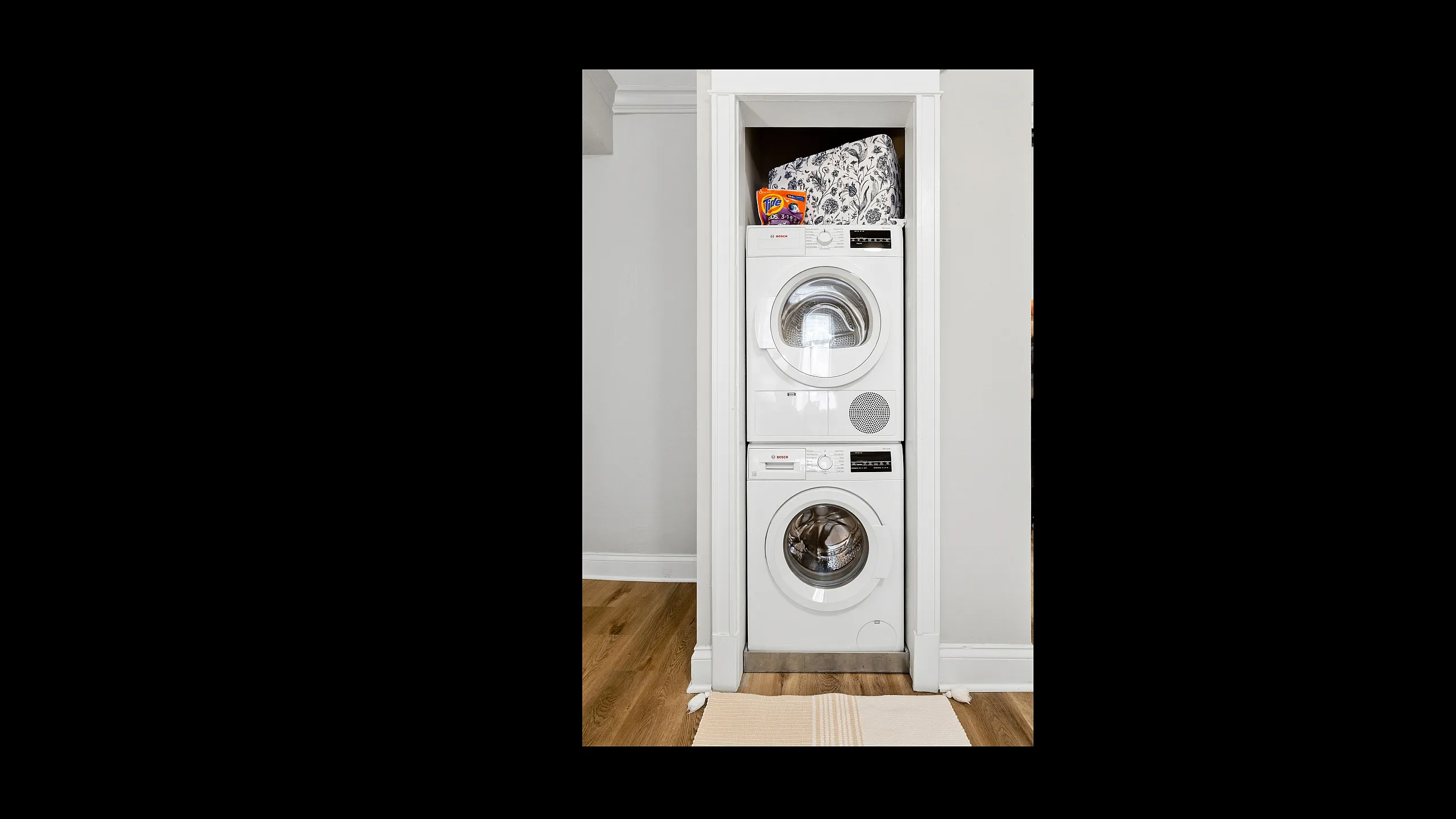 Chic apartment laundry nook featuring a stacked Bosch washer-dryer, maximizing space with elegance and efficiency.