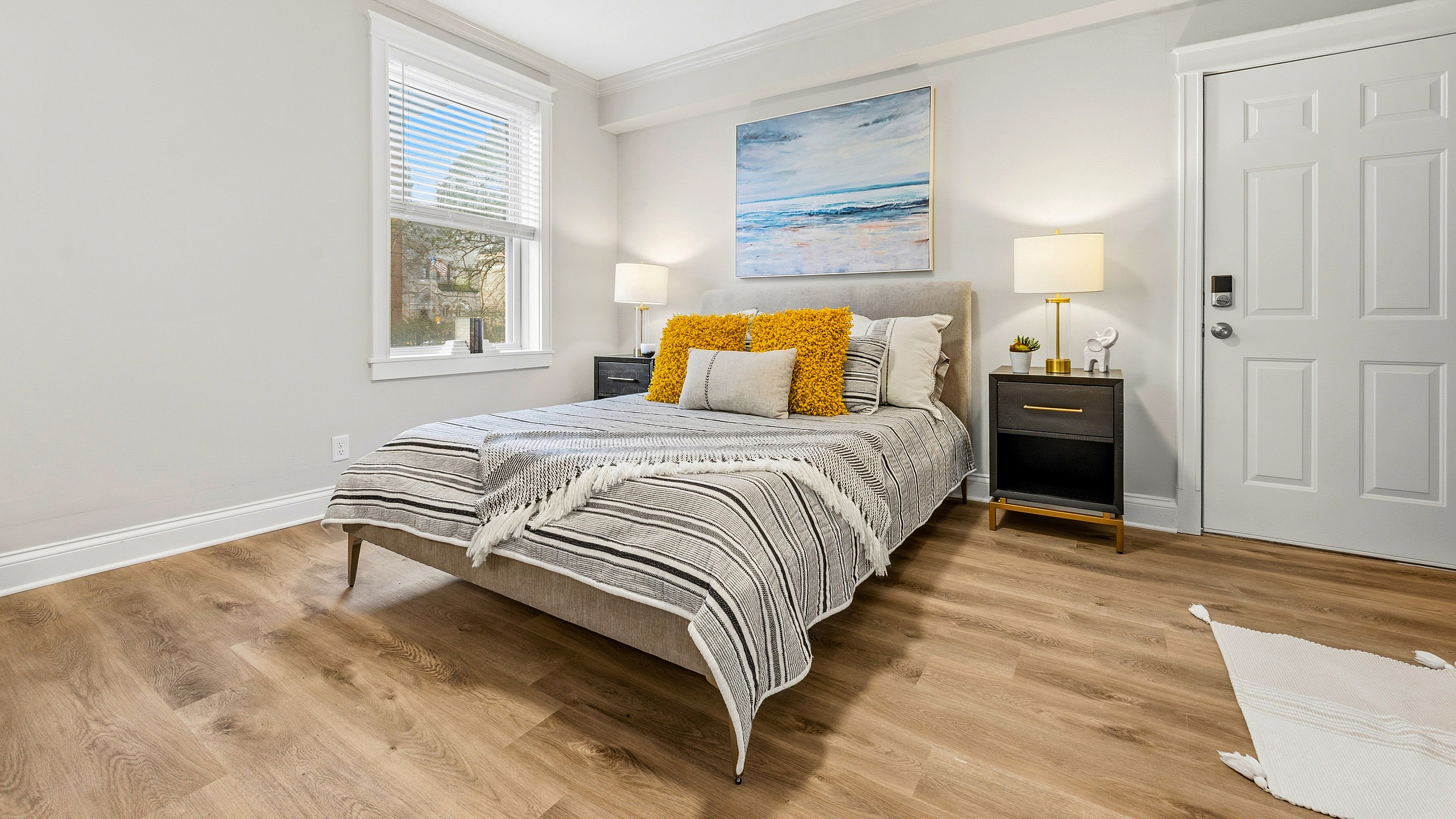 Inviting bedroom with elegant furnishings, wooden flooring, and abundant natural light.