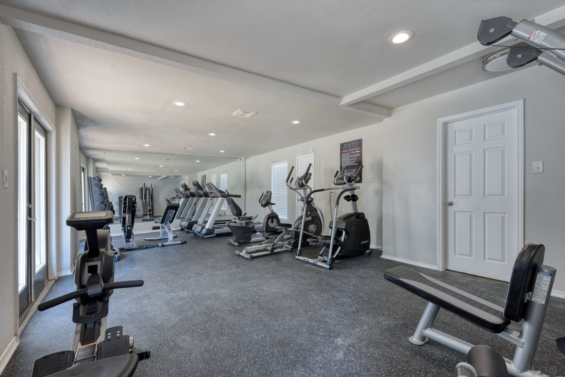 Modern fitness center with state-of-the-art exercise equipment and sleek design, offering a spacious, well-lit environment for workouts.