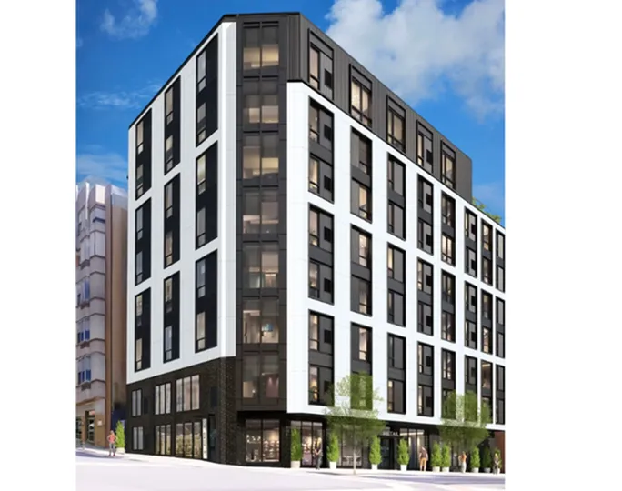 Modern urban apartment building with sleek black and white facade, featuring large windows and lush greenery at street level, under a clear blue sky.