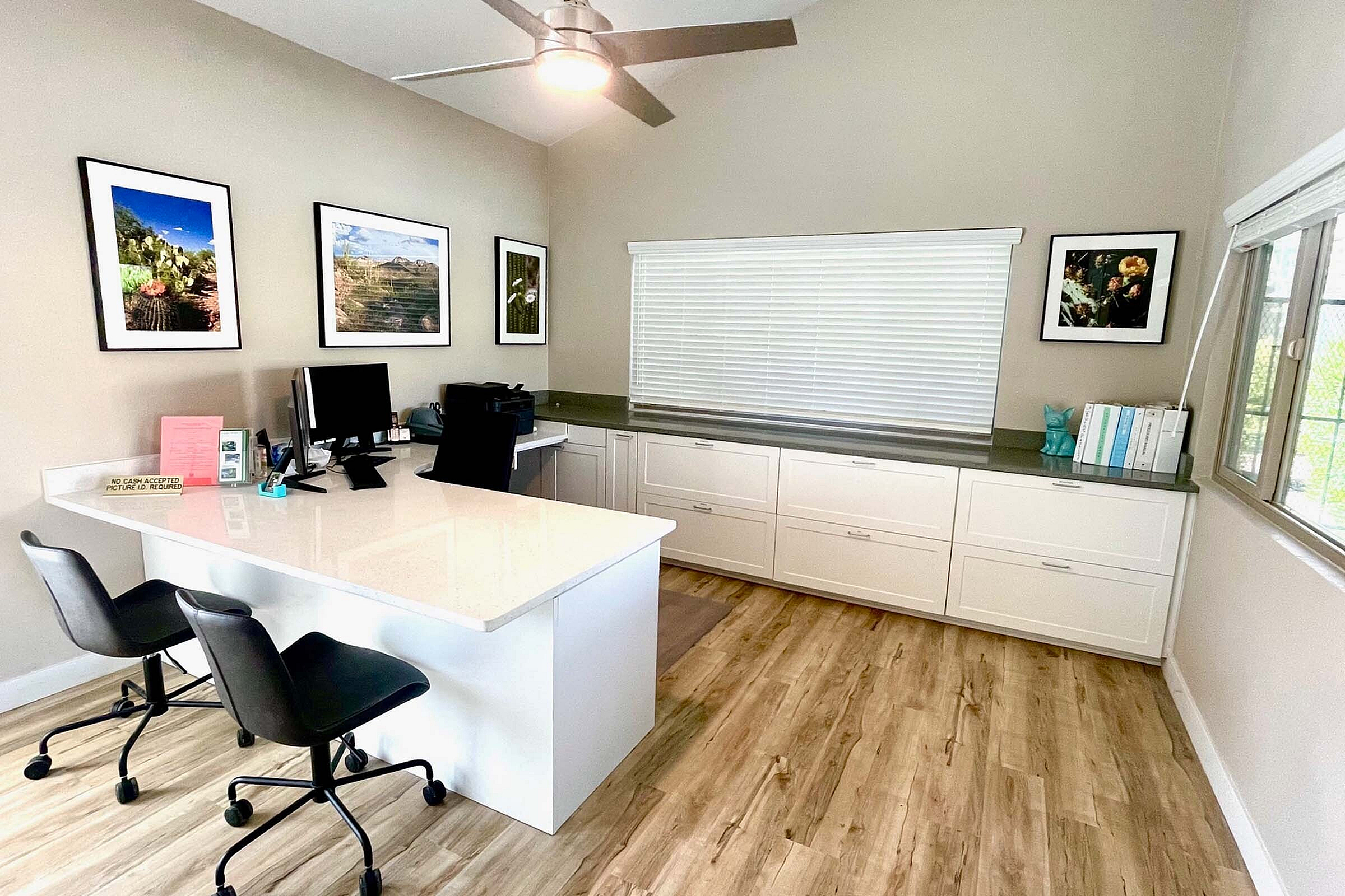 Bright and modern home office with stylish decor, sleek white cabinetry, and a spacious desk with ergonomic chairs.