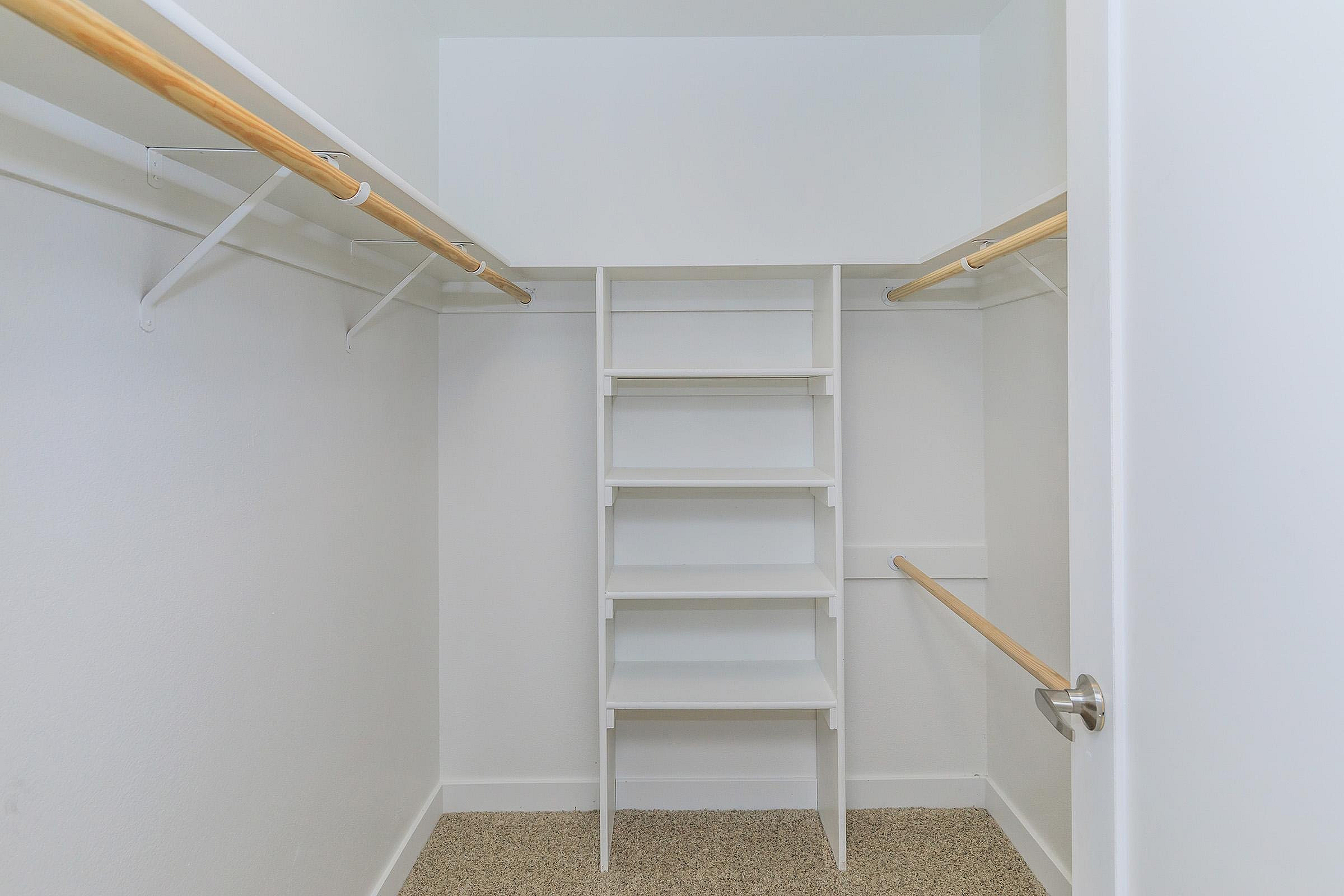 Spacious walk-in closet with built-in shelves and ample hanging space for optimal organization.