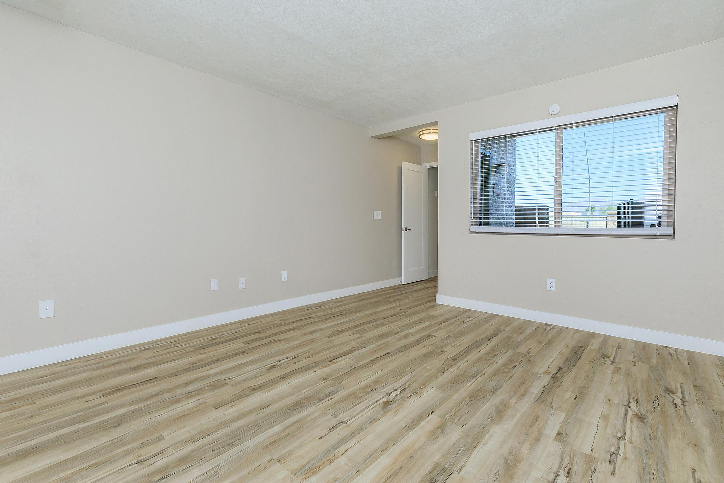 Bright, open room featuring elegant hardwood flooring and a large window inviting natural light.