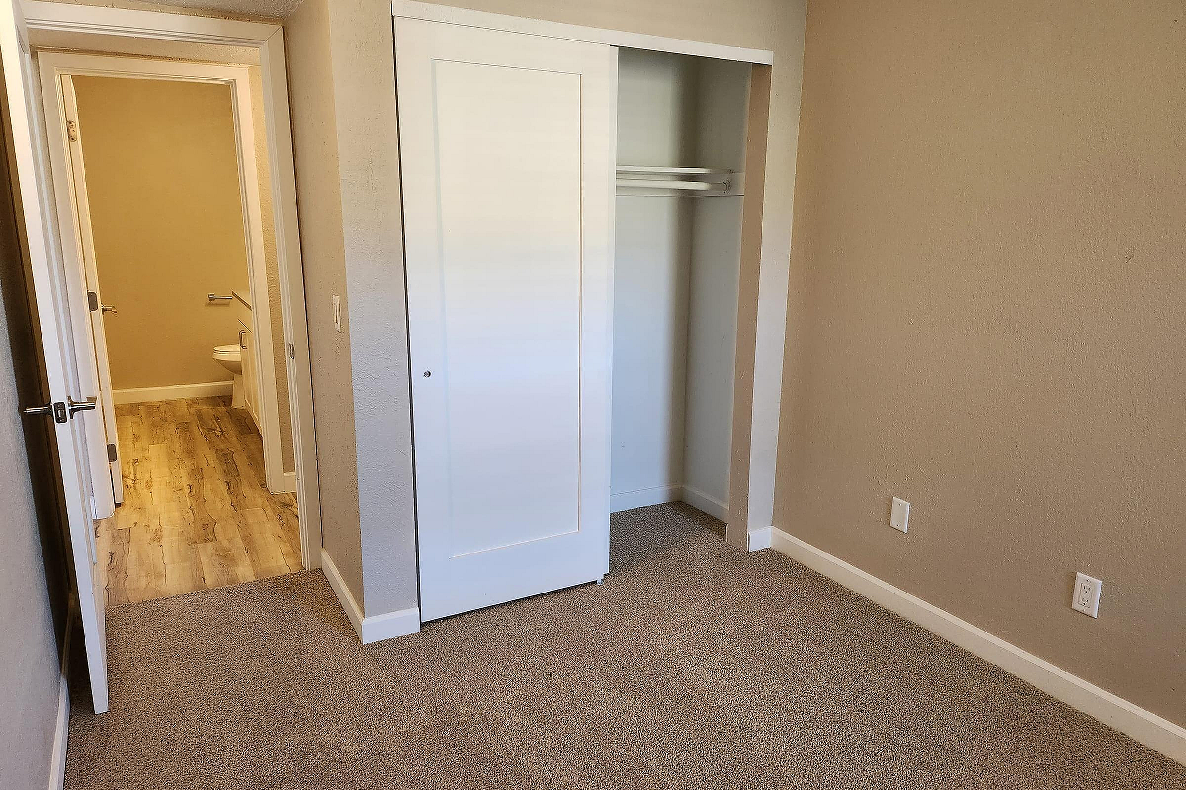 Cozy bedroom with soft carpet flooring, built-in closet, and a convenient ensuite bathroom.