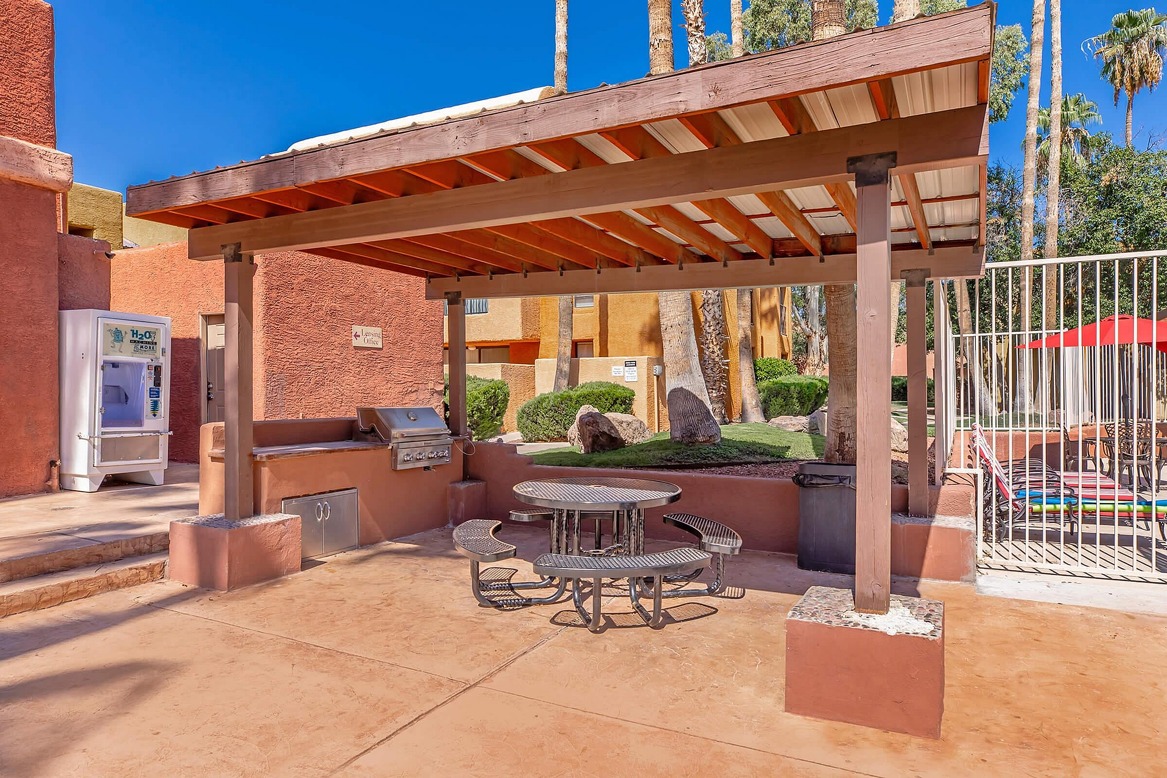 Inviting outdoor barbecue area with shaded pergola, stylish patio seating, and lush landscaping for perfect al fresco dining.