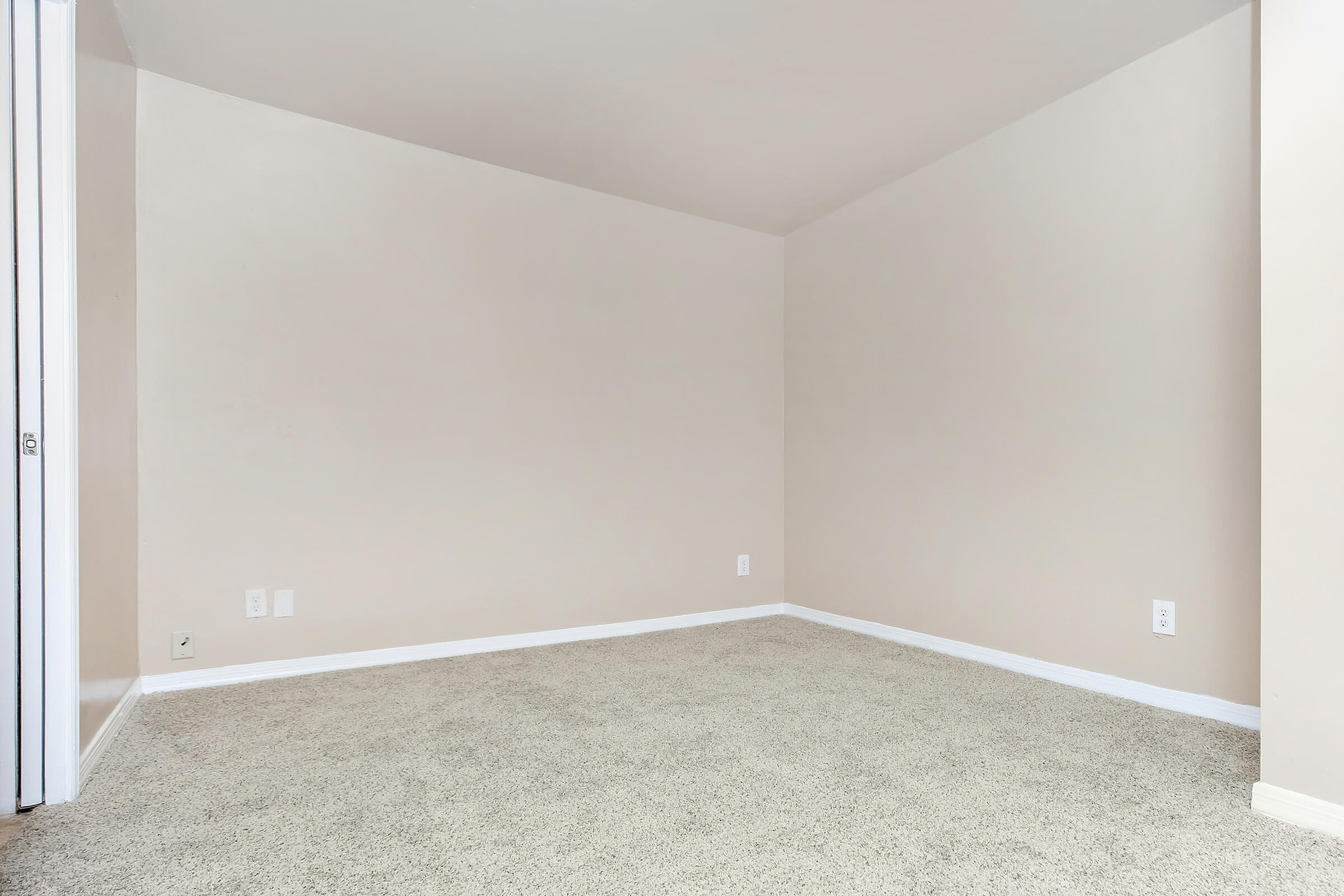 Bright, freshly painted room with plush carpet, perfect for a cozy bedroom or home office.