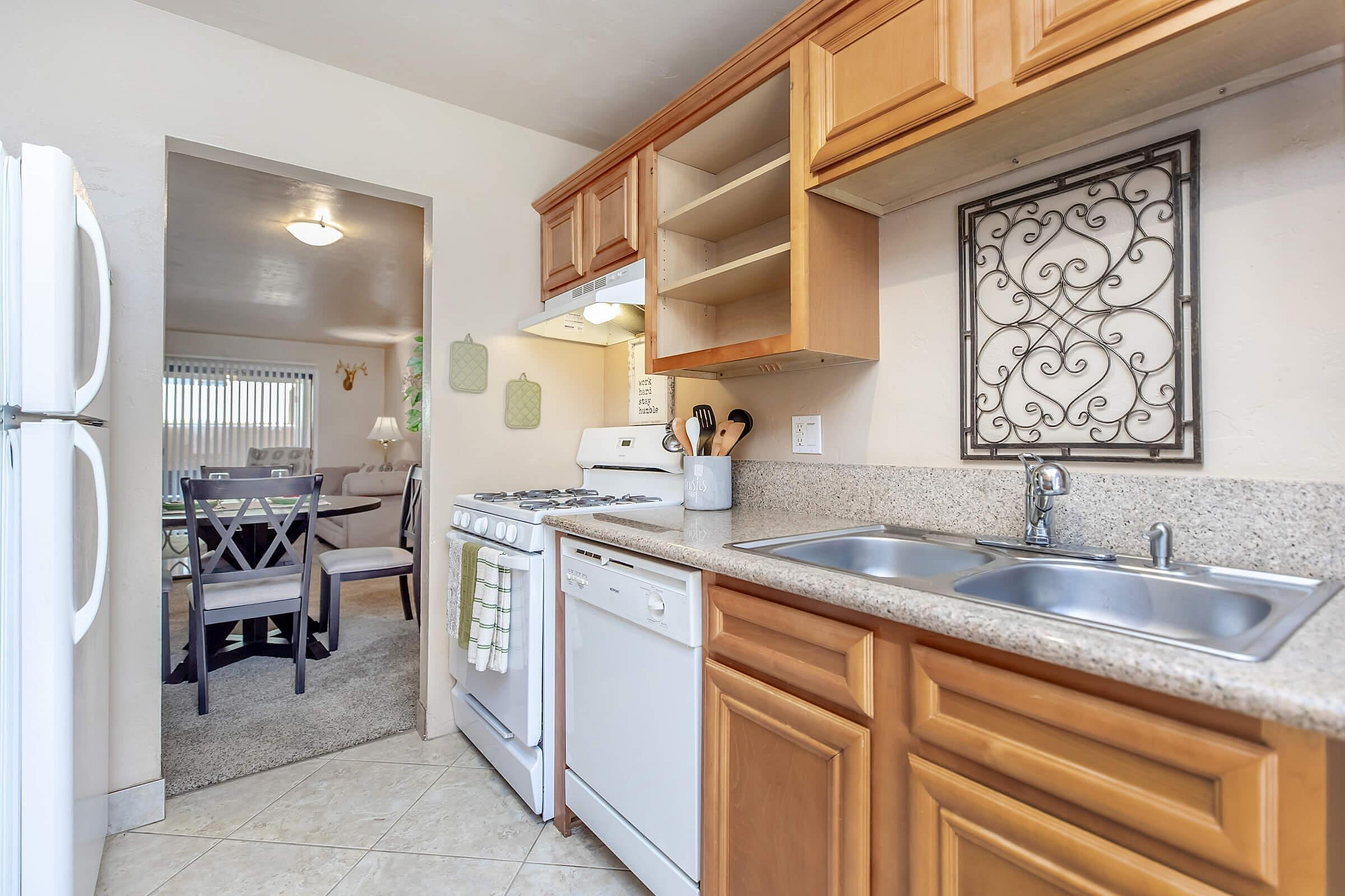 Charming kitchen with wooden cabinets, modern appliances, and a cozy dining area visible in the background.