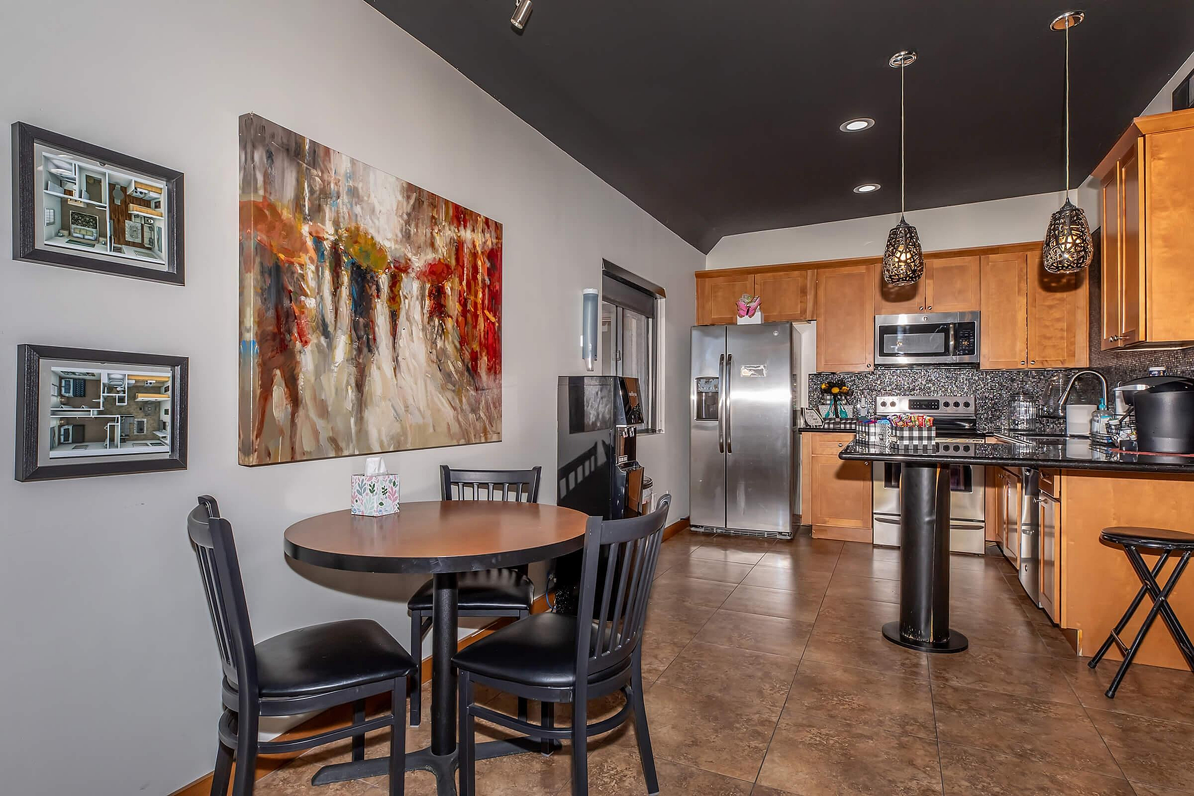 Chic kitchen and dining area with modern appliances, elegant artwork, and ambient lighting for a cozy atmosphere.