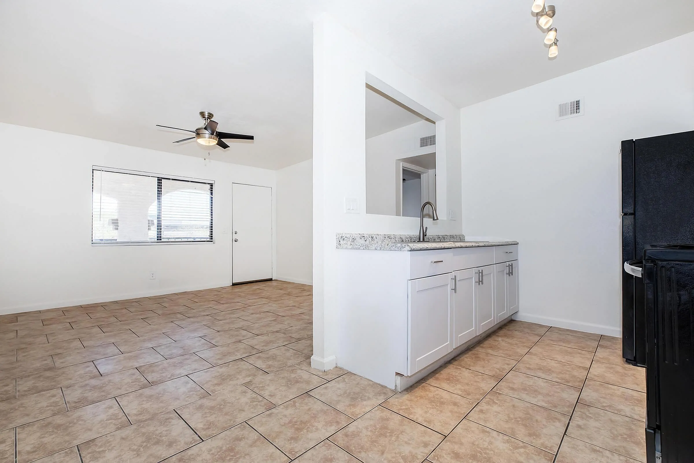 Bright and airy open-concept apartment with modern kitchen, sleek tile flooring, and abundant natural light.