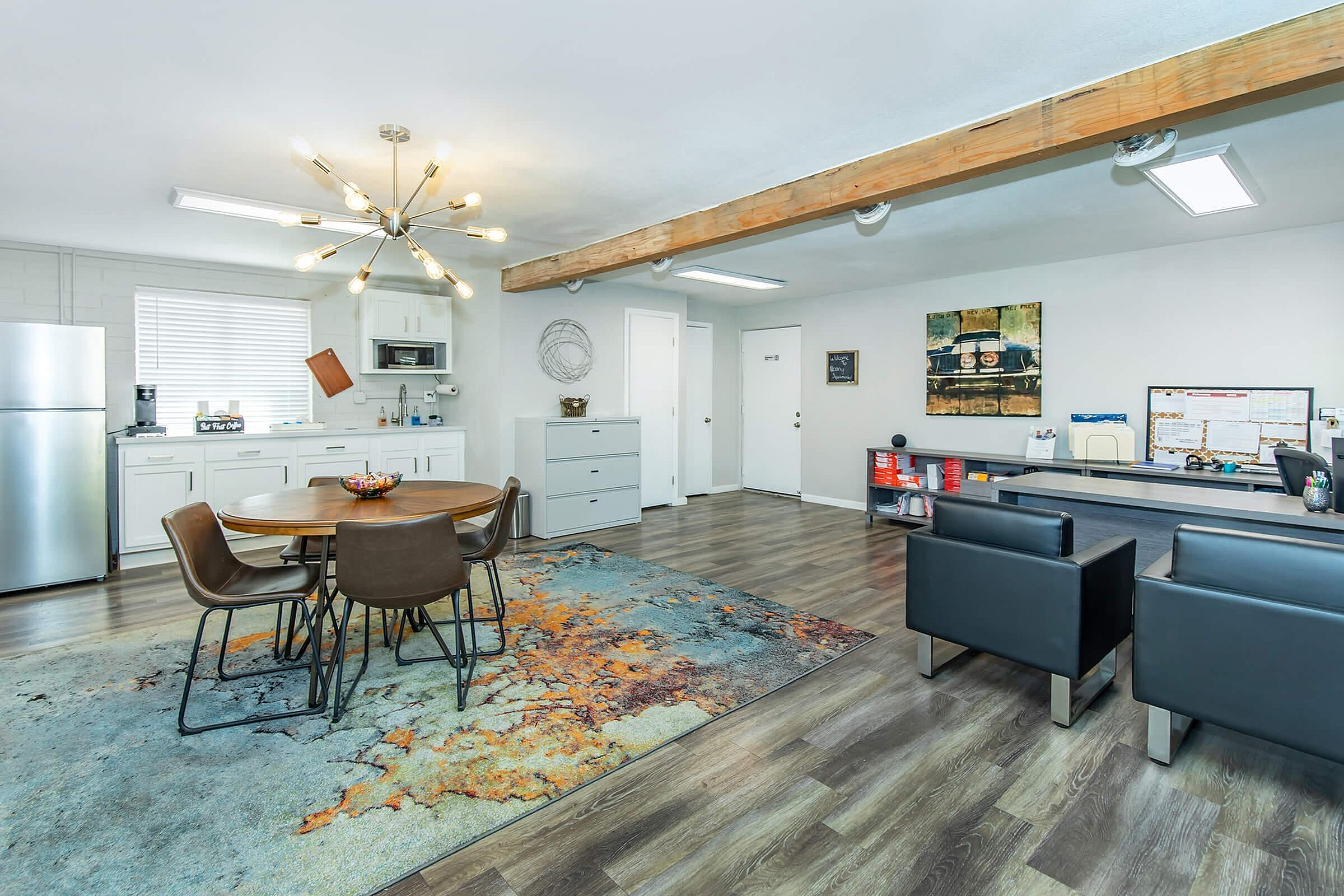 Contemporary open-plan space featuring a sleek kitchen, modern dining area with stylish lighting, and comfortable seating on elegant wood flooring.