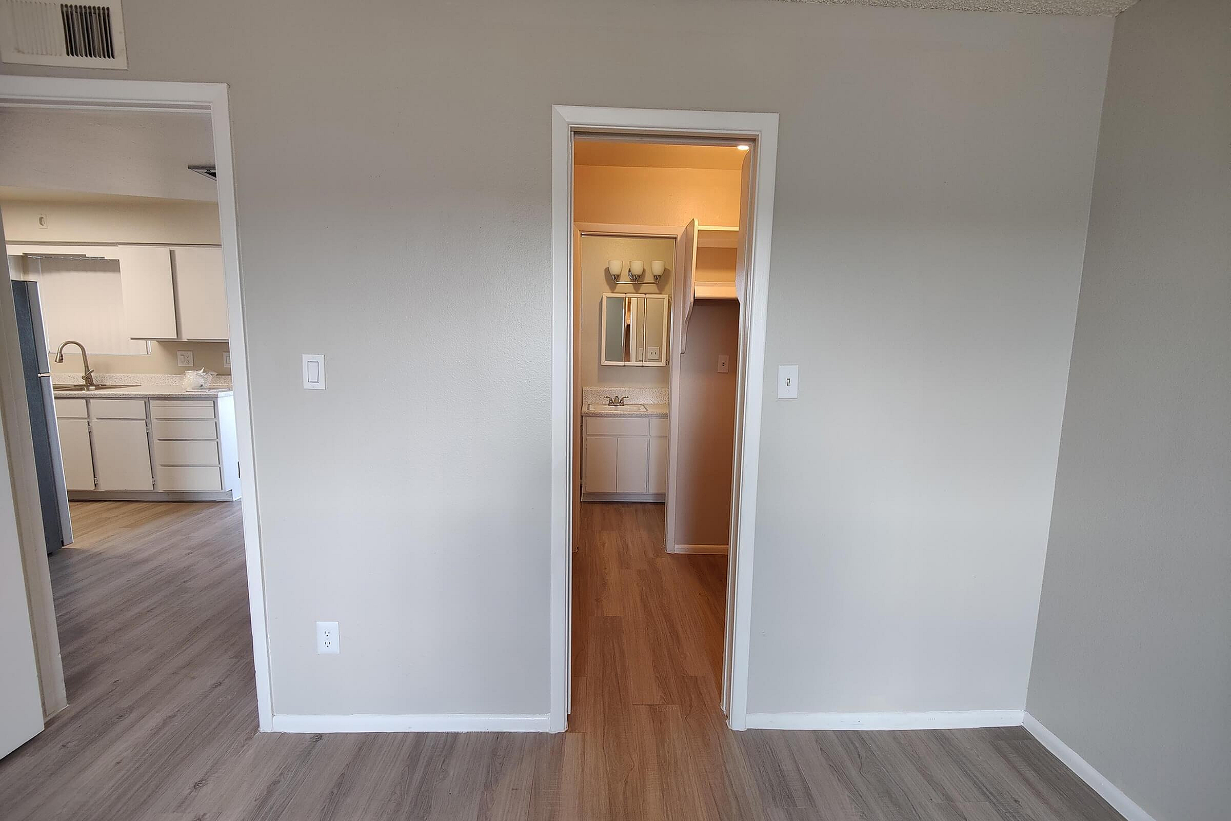 Bright apartment interior showcasing elegant hardwood floors, a modern kitchen with granite countertops, and a chic bathroom with stylish lighting.