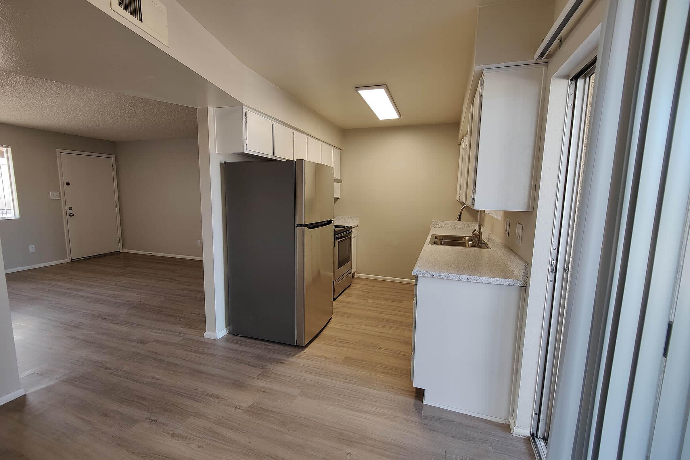 Bright and inviting open-concept kitchen with sleek stainless steel appliances and elegant flooring.