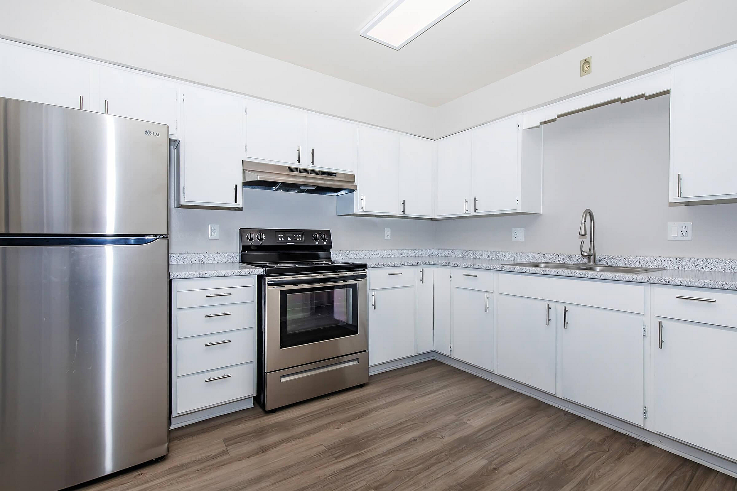 Modern kitchen with sleek stainless steel appliances, granite countertops, and elegant white cabinetry creating a bright and inviting space.