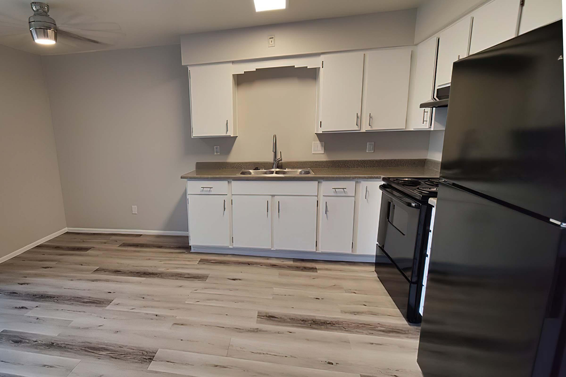 Modern kitchen with sleek appliances, white cabinetry, and elegant wood flooring, ideal for stylish living.
