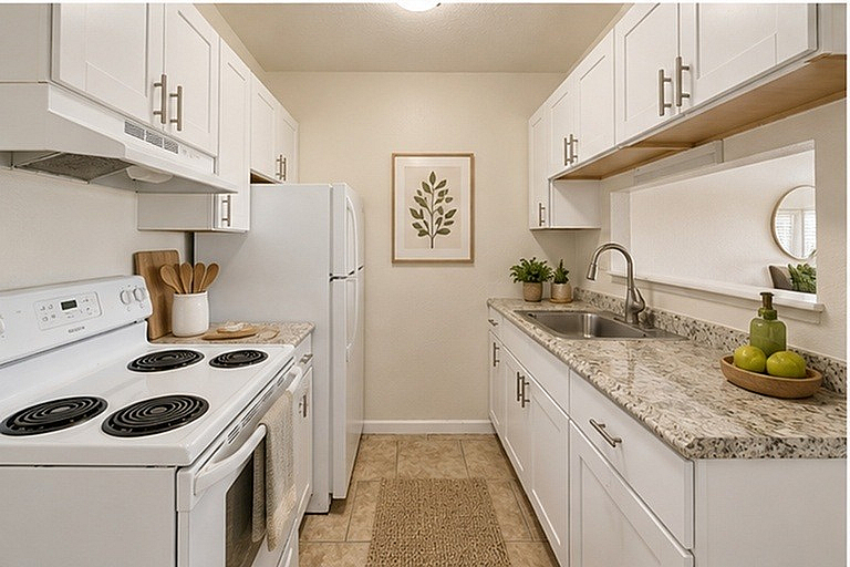 Charming kitchen with modern appliances, sleek granite countertops, and elegant white cabinetry, ideal for culinary enthusiasts.