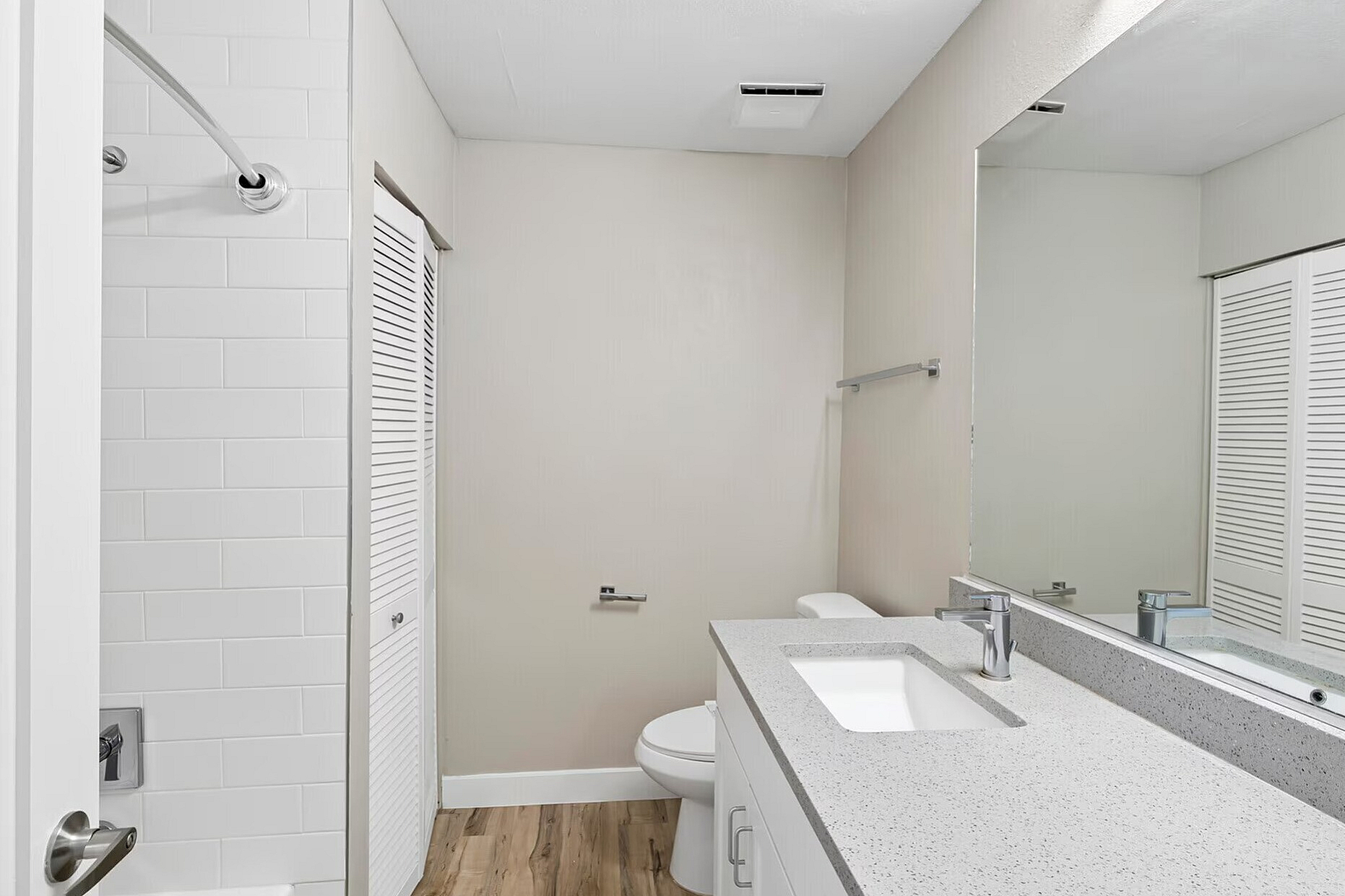 Modern bathroom with sleek white fixtures, stylish vanity, and elegant tile surrounds, offering a serene and sophisticated look.