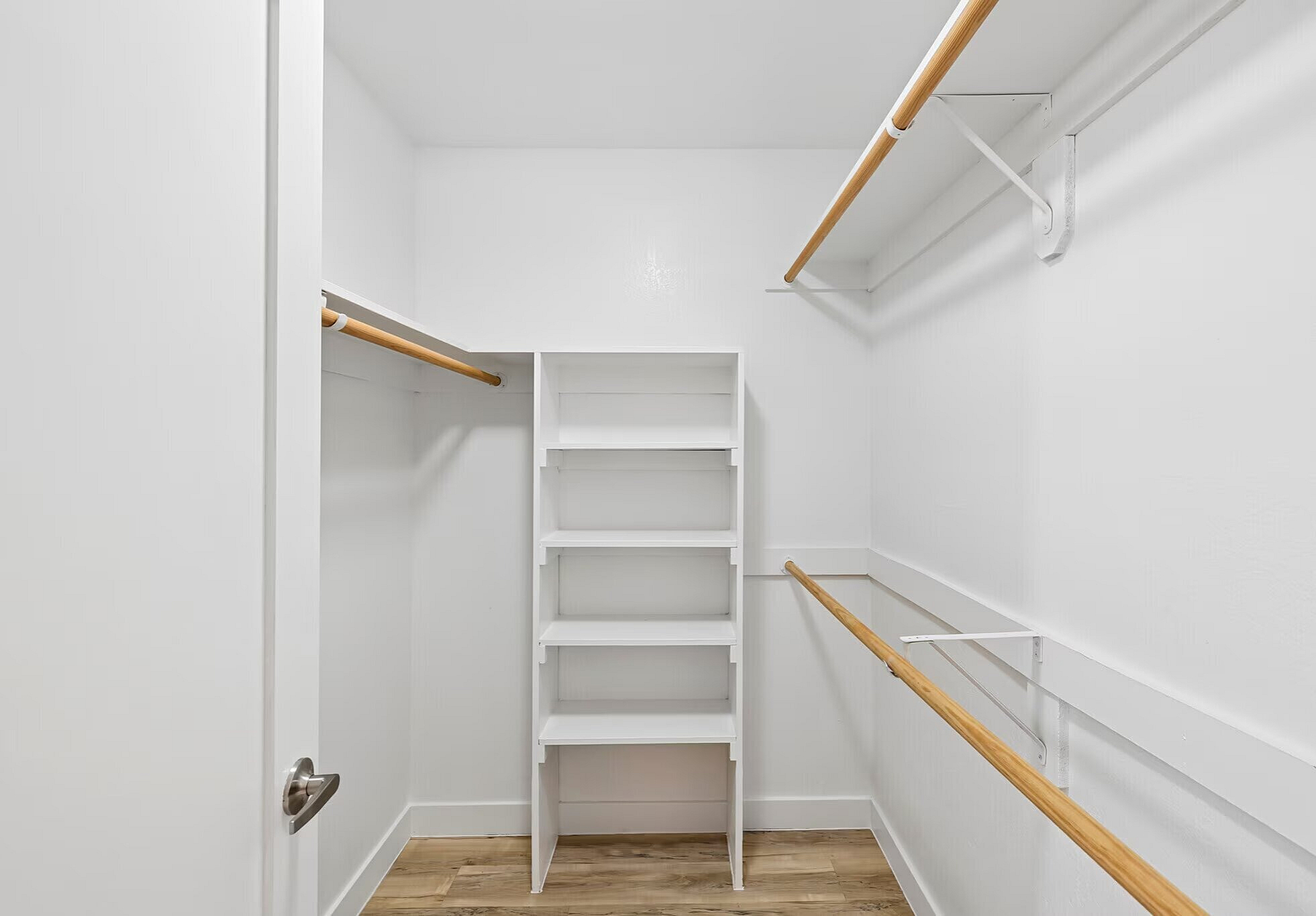 Spacious walk-in closet with sleek shelving and ample hanging space in a modern apartment.