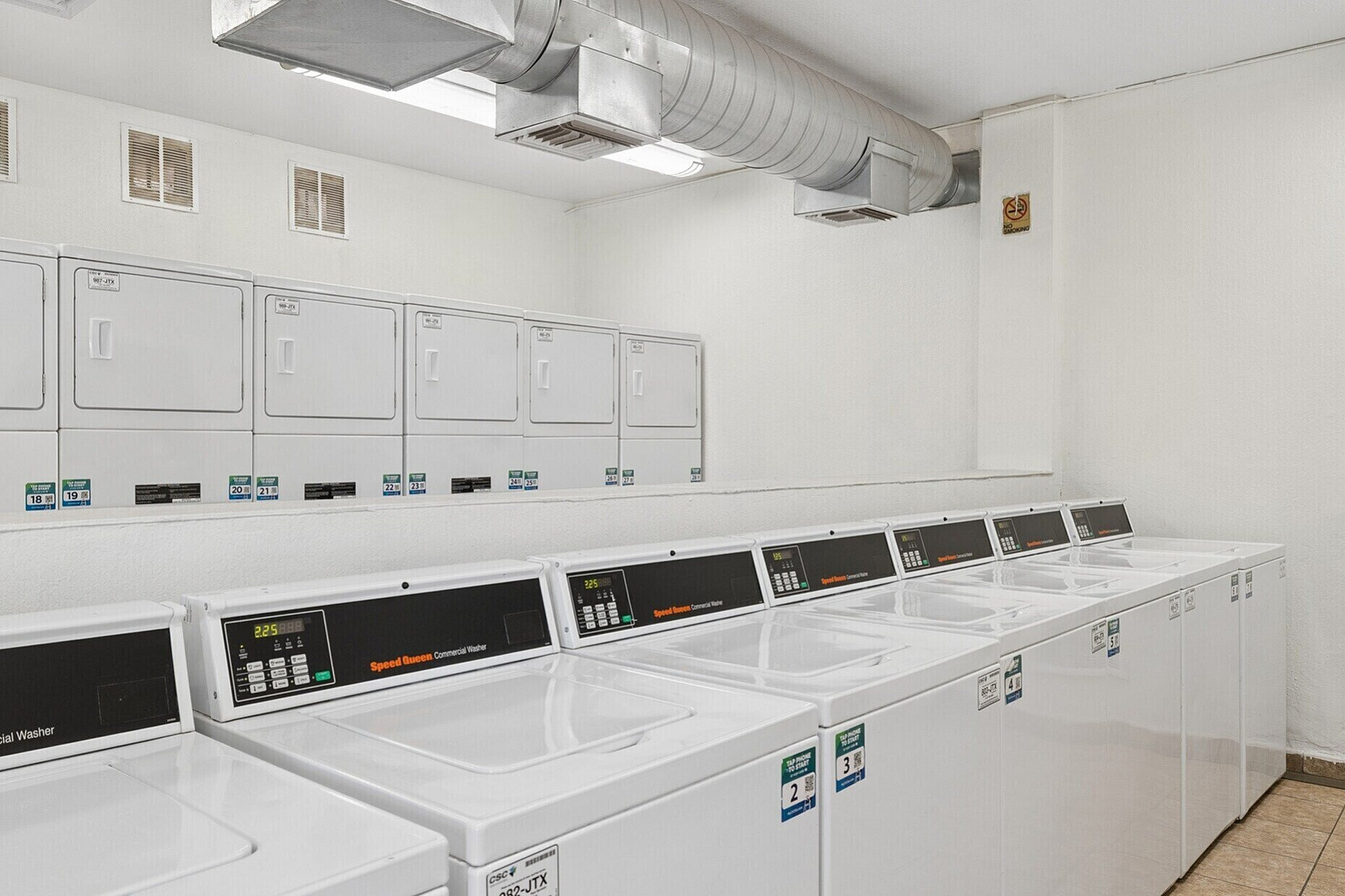 Modern laundry room with multiple Speed Queen washers and dryers, providing efficient and convenient apartment amenities.