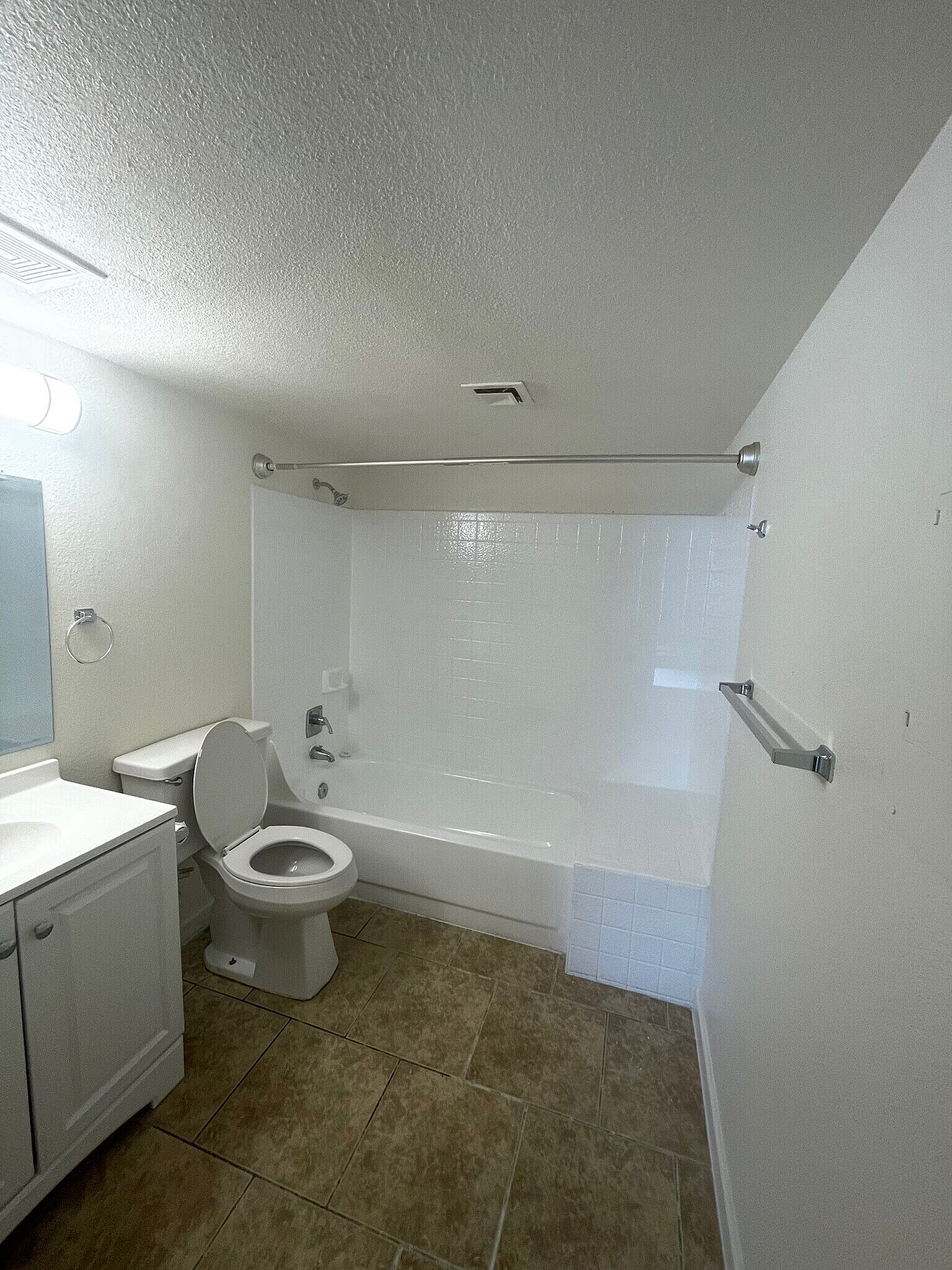 Bright modern bathroom with elegant tiling, spacious tub, and sleek vanity unit.