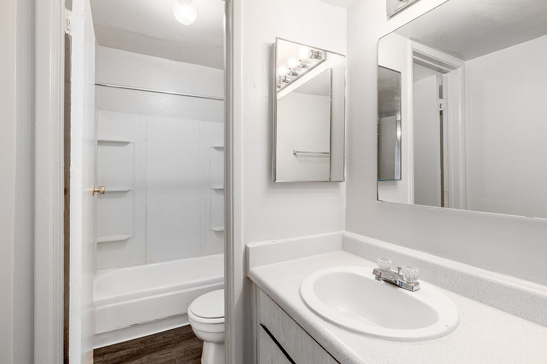 Bright, elegant bathroom with a modern vanity, large mirror, and relaxing bathtub, perfect for a tranquil home experience.