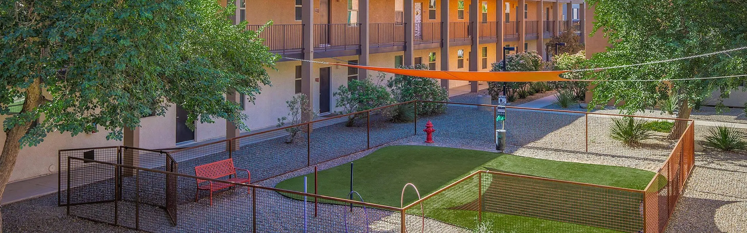 Charming apartment building with a playground, vibrant greenery, and spacious balconies, ideal for outdoor enjoyment.