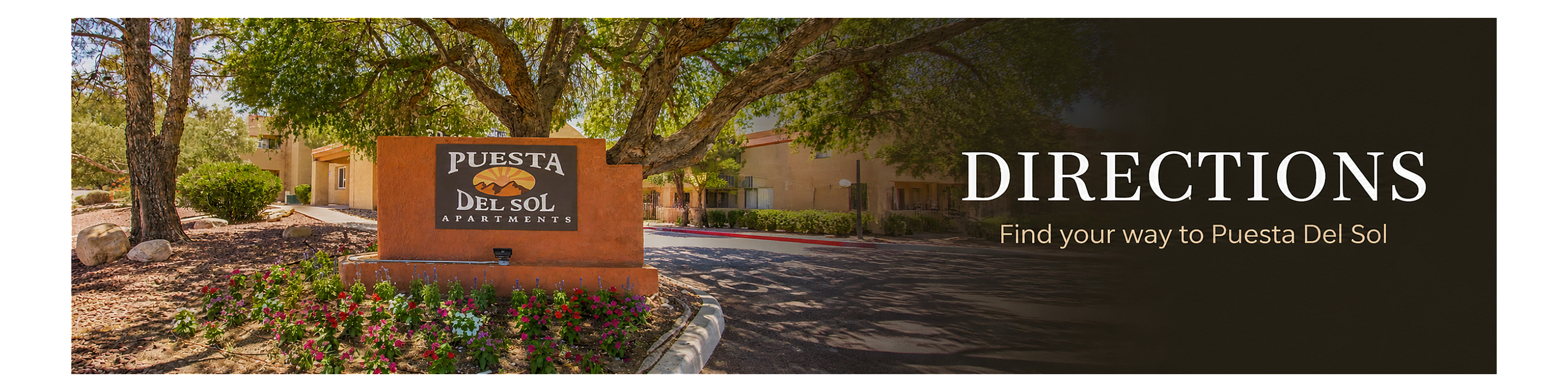 Welcoming entrance to Puesta Del Sol Apartments surrounded by lush greenery and vibrant flowers.
