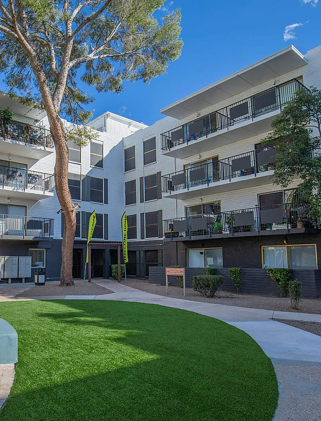 Modern apartment complex with spacious balconies and a beautifully landscaped courtyard, perfect for urban living.