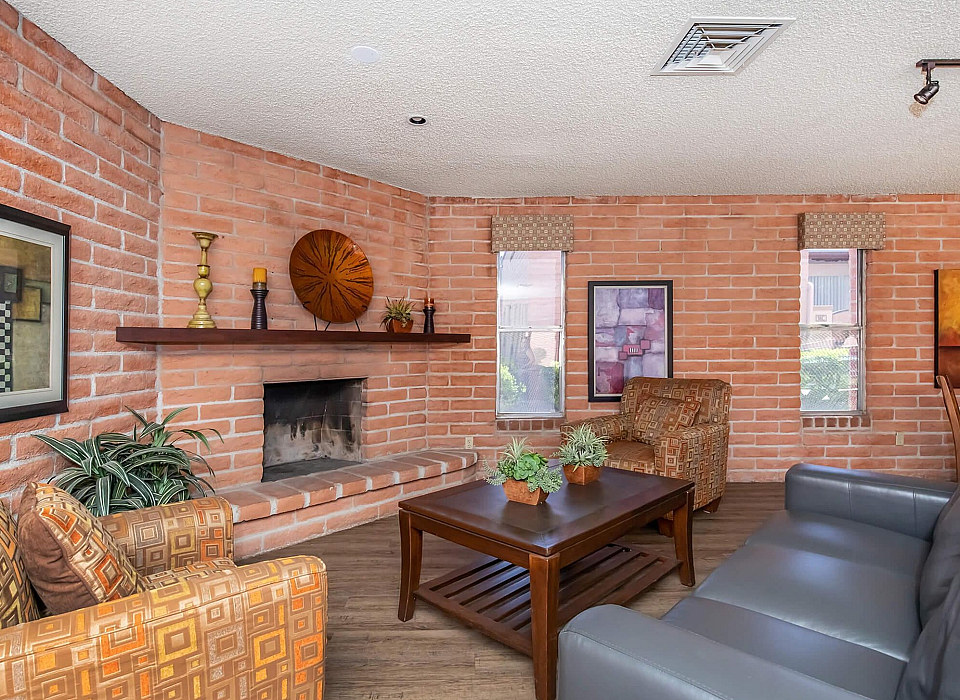 Charming living room with exposed brick walls, a cozy fireplace, elegant decor, and comfortable seating.