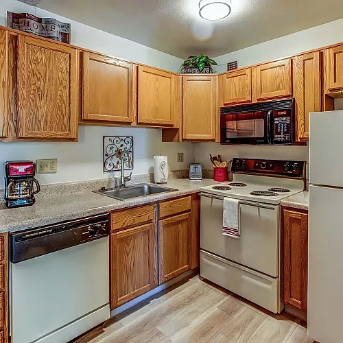 Inviting kitchen with warm wooden cabinets, modern appliances, and elegant countertops, perfect for culinary enthusiasts.