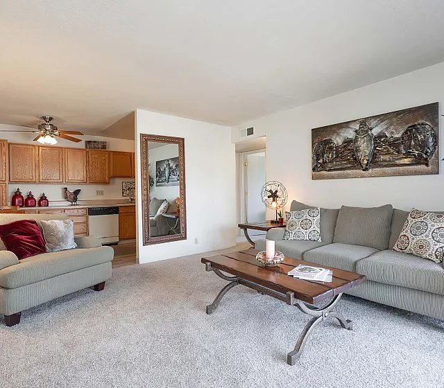 Inviting living room with plush seating, stylish decor, and open view to a cozy kitchen, perfect for relaxation and entertaining.