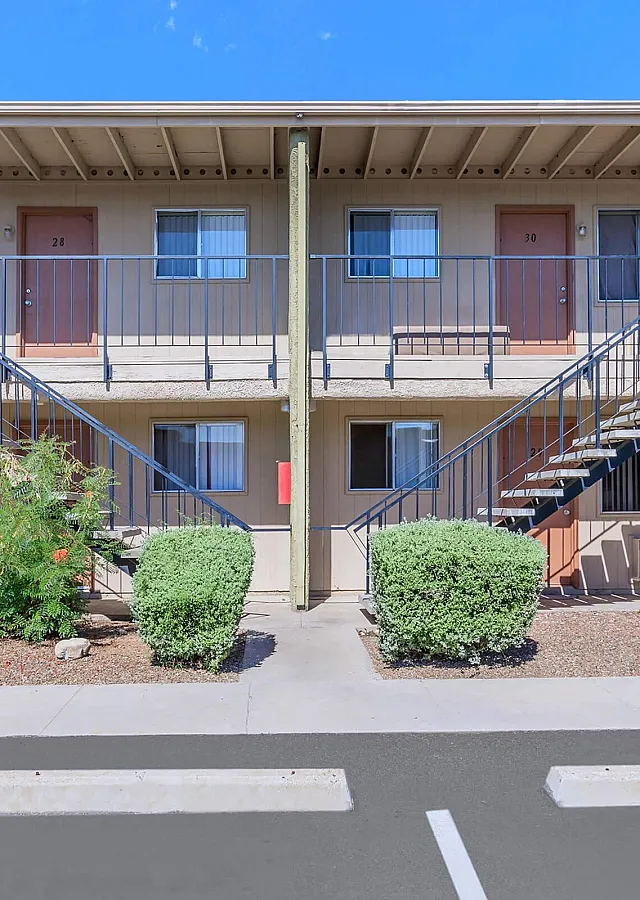 Modern two-story apartment complex with attractive landscaping, featuring clean lines and inviting entrances.