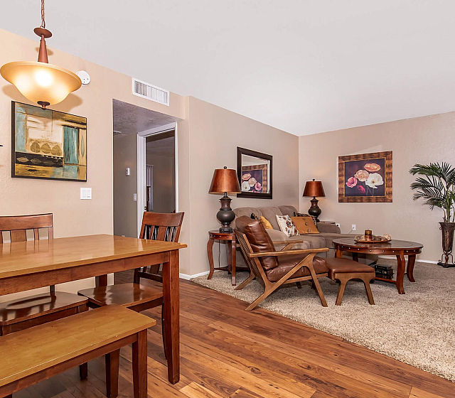Inviting living and dining area with elegant decor, featuring warm wood tones, cozy seating, and stylish lighting.