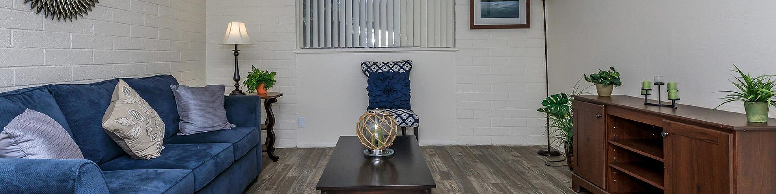 Inviting living room with elegant blue sofa, chic decor, and light wood flooring, perfect for relaxation and entertaining.